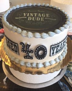 a cake that is decorated with the number forty and has an old fashioned sign on it