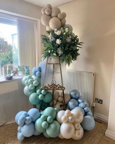 an arrangement of balloons and flowers in a room