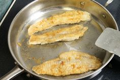 some fish are cooking in a pan on the stove