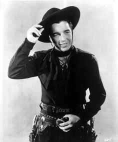 black and white photograph of a man wearing a cowboy hat with his hand on his hip