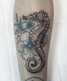 a black and white photo of a seahorse with flowers on it's leg