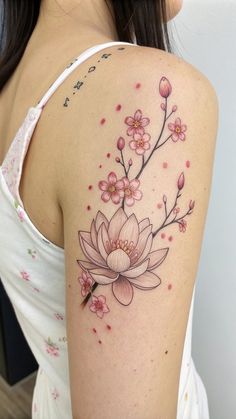 a woman's shoulder with pink flowers on her arm and the back of her body