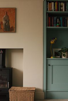 a living room with bookshelves and a television in the corner next to a basket