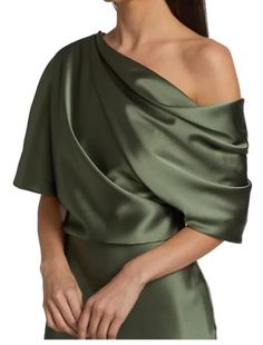 a woman in a green dress with one shoulder draped over her shoulders and the other half down