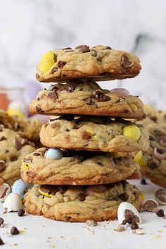 chocolate chip cookies stacked on top of each other with easter eggs in the middle and candy bits scattered around them