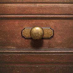 an old wooden drawer with a brass knob