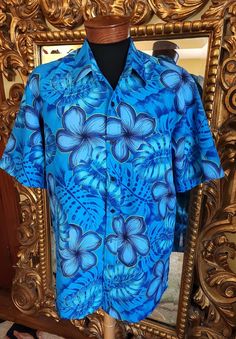 "This beautiful mens Hawaiian shirt is from the 70's.  Made of a thicker polyester.  The pattern features large flowers outlined in a metallic gold. The gold is faint in some areas but the rest of the colors are still vibrant.  There is no label inside.  Please see the measurements below for a proper fit.  I believe this would fit a XL/2X no problem.  All sales are final. Measurements Armpit-armpit doubled 50\" Shoulder 19\" Length 32\"" Blue Hawaiian Shirt With Floral Print And Camp Collar, Blue Collared Hawaiian Shirt With Floral Print, Blue Floral Print Hawaiian Shirt For Beach, Blue Tropical Shirt With Floral Print, Blue Floral Print Shirt With Camp Collar, Blue Hawaiian Shirt With Hibiscus Print For Spring, Blue Hawaiian Shirt With Hibiscus Print For Beach, Blue Tropical Camp Shirt With Floral Print, Spring Blue Hawaiian Shirt With Hibiscus Print