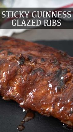 a close up of a piece of meat on a plate with text that reads sticky guinness glazed ribs