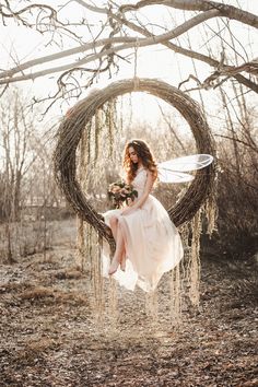 a woman in a white dress sitting on a tree branch