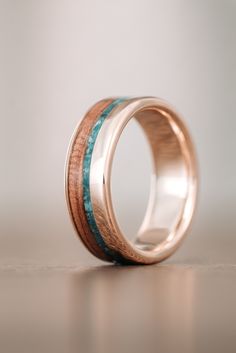 a wedding ring with two wood and turquoise stone inlays on the inside of it