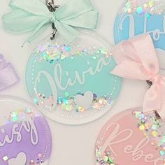 four personalized keychains with bows and sequins on them are shown