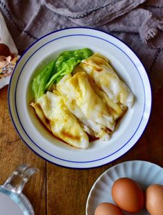 some food is in a white bowl on a wooden table next to eggs and an egg carton