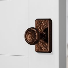 a close up of a door handle on a white door with a brown metal knob