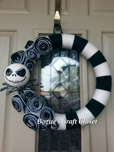 a halloween wreath with jack skellings and a skull hanging from the front door