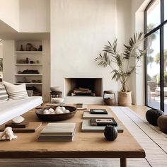 a living room filled with furniture and a fire place in front of a large window