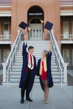 two people in graduation gowns holding up their hats