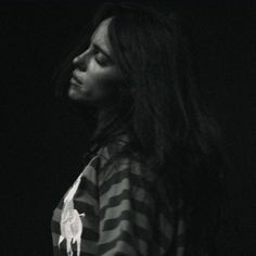 a woman with long hair standing in the dark