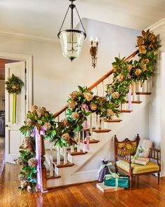 a staircase decorated with greenery and ribbons for the holiday season is seen in this image