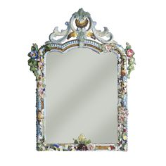 an ornate mirror with flowers and leaves painted on the frame, is shown against a white background