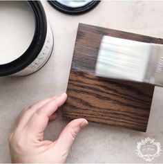 a person is using a brush to paint the wood on a piece of furniture with white paint