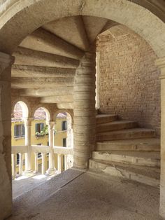 an arched doorway with stone steps leading up to the second floor and another set of stairs on either side