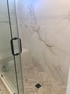 a walk in shower sitting inside of a bathroom next to a tiled wall and floor