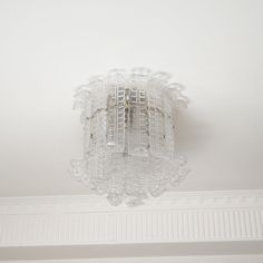 a chandelier hanging from the ceiling in a room with white walls and ceilings