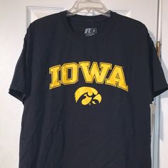 a black t - shirt with the word iowa on it hanging from a hanger