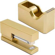 two gold colored office supplies on a white background, one has a roll of toilet paper in it