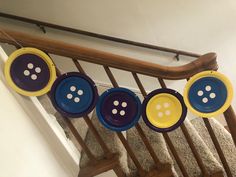 some yellow and blue plates are hanging from a banister