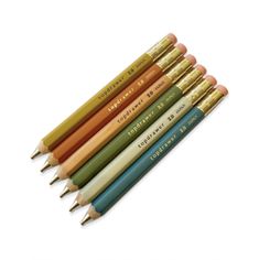 six different colored pencils with writing on them