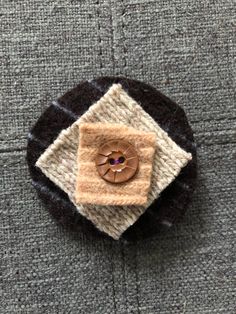 a brown button sitting on top of a piece of cloth