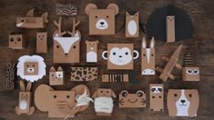 cardboard cut out animals and other items on a wooden table with scissors, tape, paper