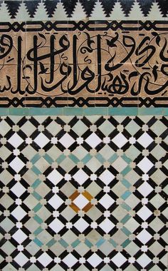 arabic calligraphy is displayed on the side of a building with geometric patterns and designs