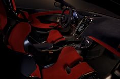 the interior of a sports car with red seats and black flooring, including a steering wheel