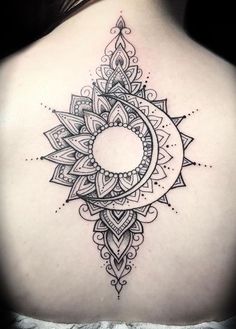 the back of a woman's shoulder with a circular tattoo design on her upper