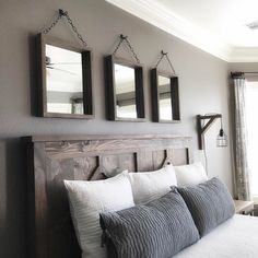 three mirrors hanging on the wall above a bed