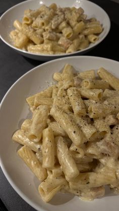 two white plates filled with pasta and meat