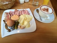 a breakfast plate with eggs, ham, cheese, and other food items on it