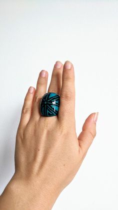 a woman's hand with a ring on top of her finger, against a white background