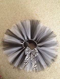 a zebra print tutule with a black and white bow on the top is laying on the floor