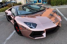 a metallic colored sports car parked in a parking lot