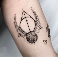 a black and white photo of a tattoo with an arrow, heart, and bow