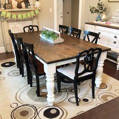 a dining room table with chairs and a potted plant sitting on top of it