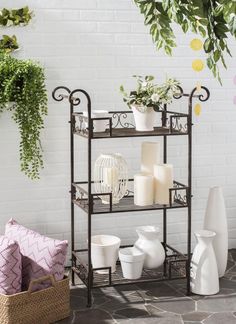 a shelf with candles, vases and other items on it in front of a white brick wall