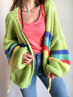 a woman wearing a green cardigan with multicolored stripes