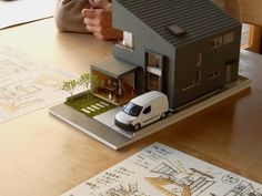 a model house with a car parked in front of it on top of a table