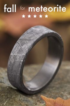 a wedding band that looks like it has been made out of wood and is sitting on top of a rock