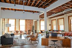 an open living room with chairs, tables and couches in the middle of it