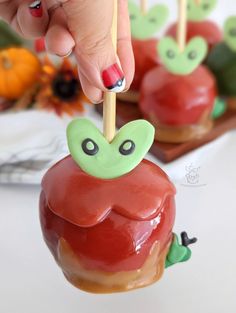 a person is picking up an apple on a stick